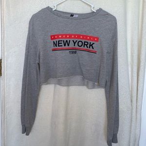A grey “Power of girls New York” croptop